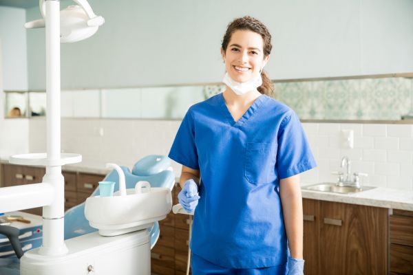 Un pacient, pe scaunul dentistului se plânge de durere