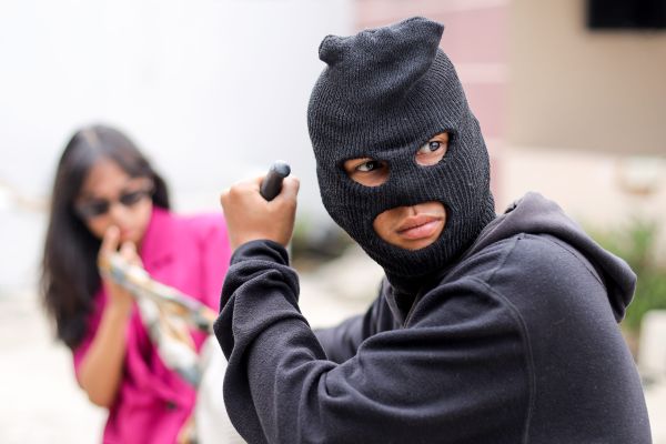 Un hoț amenință un om pe stradă