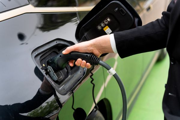 Intrebare:- Ce face un șofer în timp ce își lasă mașina electrică la încărcat?